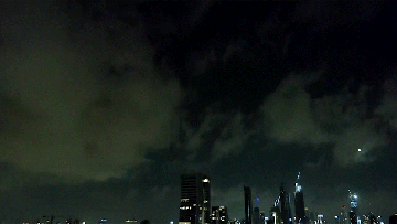 Nighttime cityscape under a dark, cloudy sky.