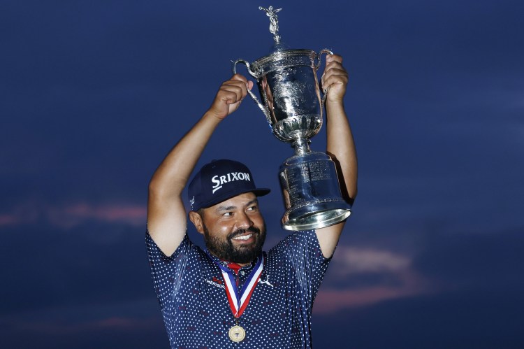 J.J. Spaun celebrates winning the U.S. Open, holding the trophy aloft.