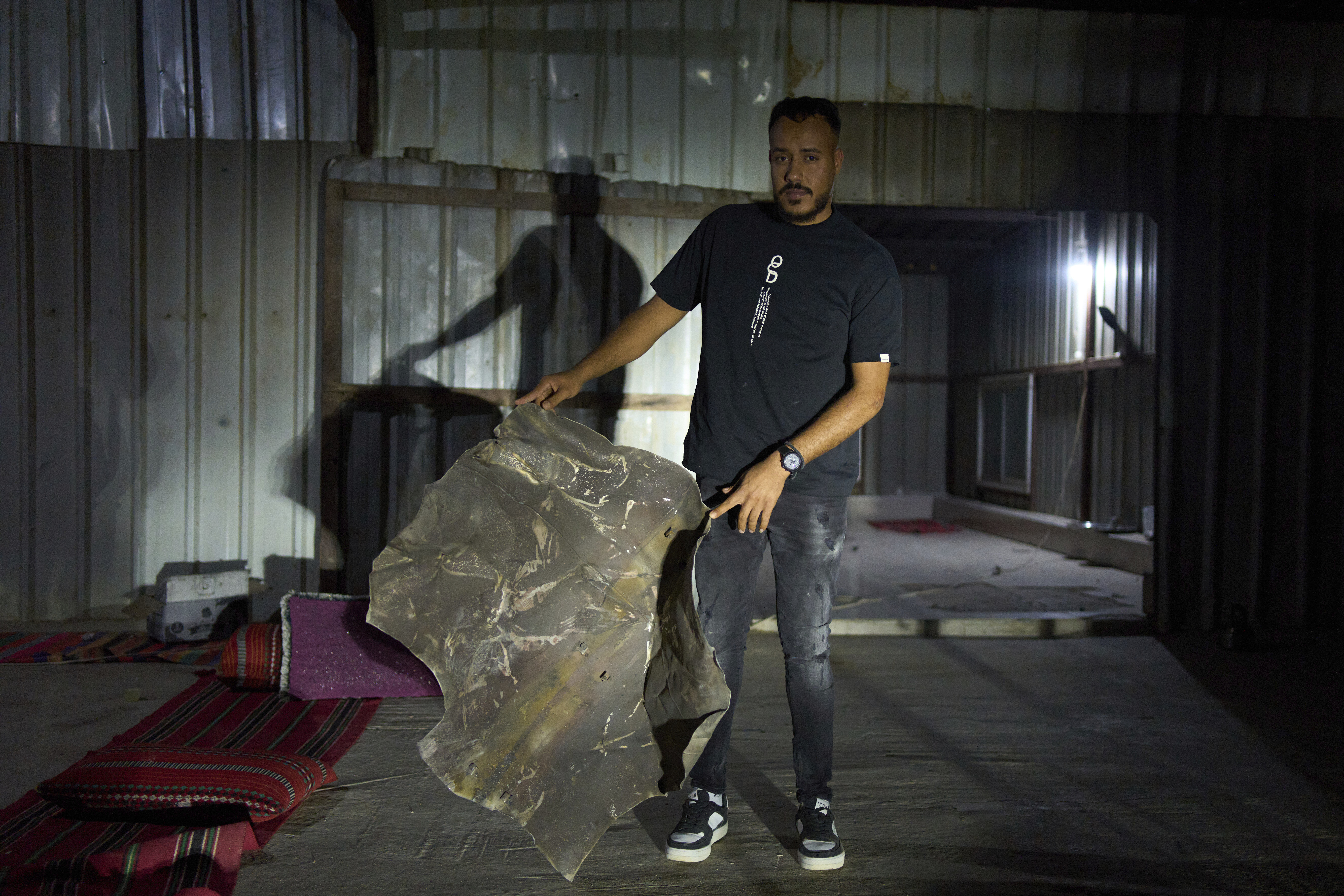 Suleiman Gaboa displays a sheet of steel from a projectile that fell on his Bedouin community in the Negev desert in southern Israel