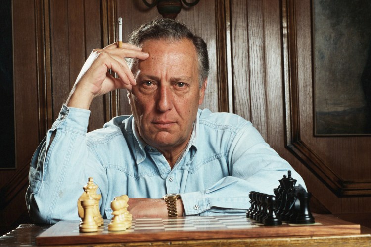 Portrait of Frederick Forsyth playing chess.