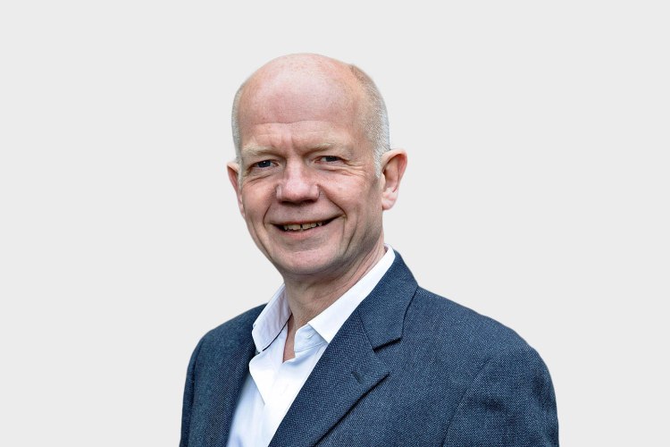 a man in a suit and white shirt smiles for the camera