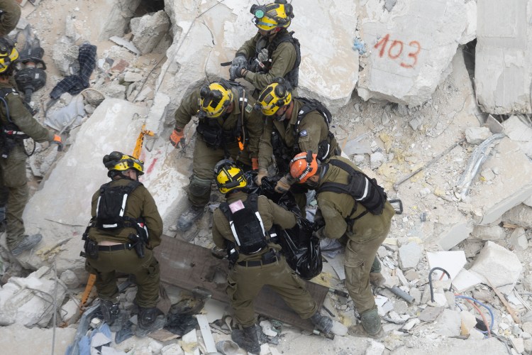 Emergency workers extract a corpse from a building in Bat Yam, Israel, that was badly damaged in an Iranian airstrike