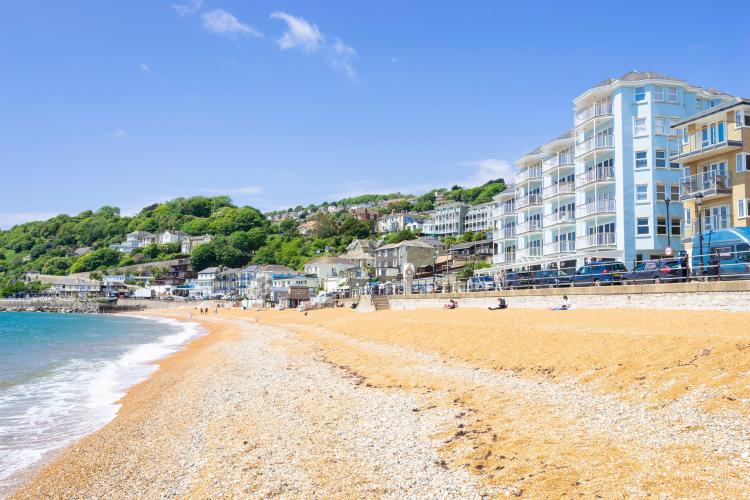 Ventnor beach in the Isle of Wight, England, with hotels and cafes along the promenade.