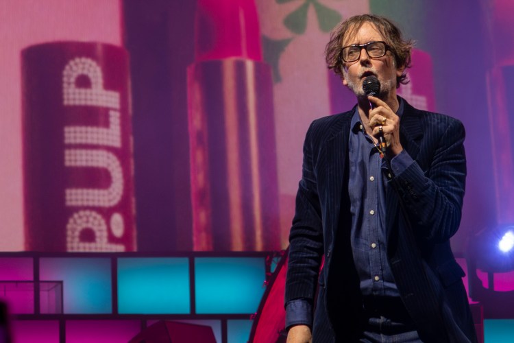 Jarvis Cocker of Pulp performing on stage.