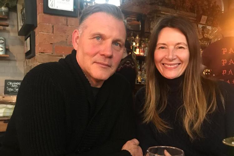 A man and woman seated at a pub table.