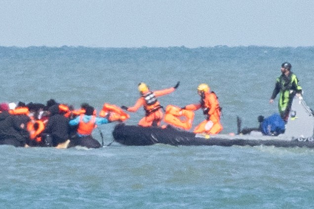 Migrants in a small boat being assisted by French authorities in the English Channel.