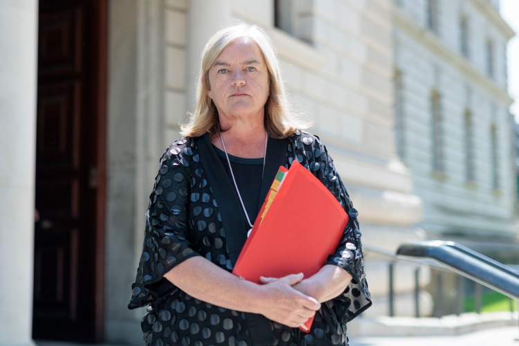 Baroness Louise Casey holding a red file folder.
