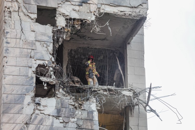 Rescue worker in a damaged building after a missile strike.
