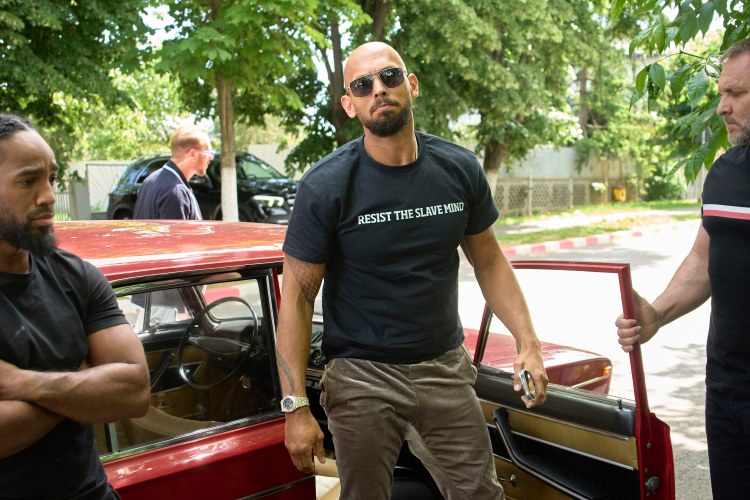 Andrew Tate arriving at a police station in Romania.