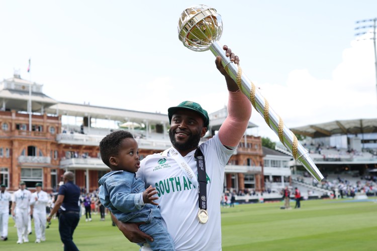 Temba Bavuma of South Africa holding his son and celebrating with the World Test Championship trophy.