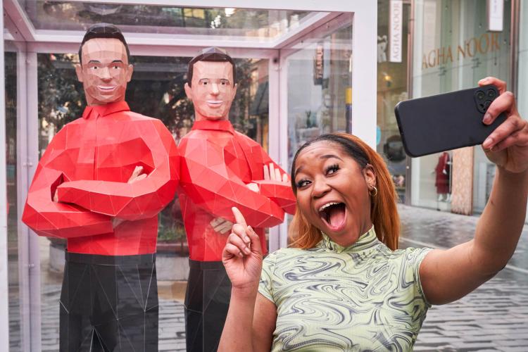 Woman taking a selfie with life-size origami statues of Ant & Dec.