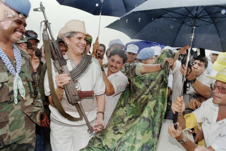 Nicaraguan President Violeta Chamorro receives an AK-47 assault rifle.