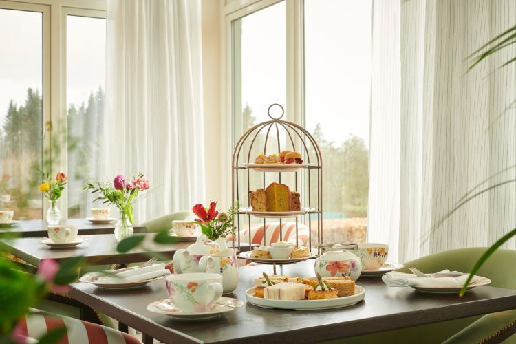 Afternoon tea setting with pastries and teacups.