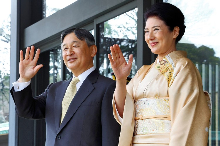 Emperor Naruhito and Empress Masako waving.