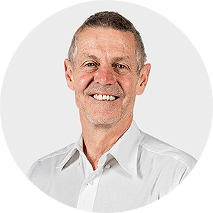 a man in a white shirt smiles for the camera